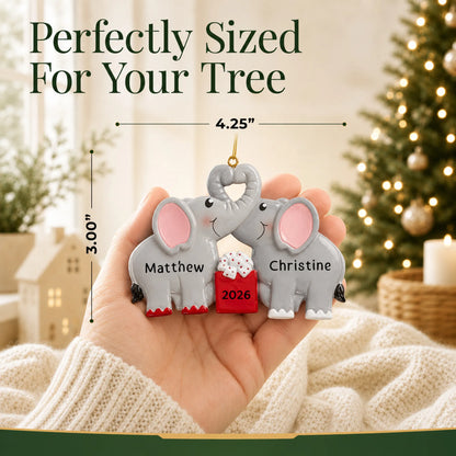 Size guide: the personalized elephant love couple christmas ornament is 4.25 in wide by 3.00 in tall, shown in hand