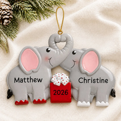 Personalized elephant love couple christmas ornament laid on a soft white knit blanket