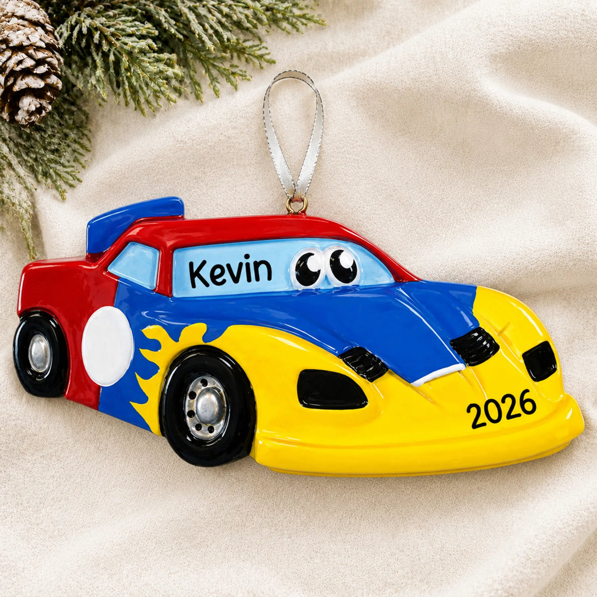 Personalized race car christmas ornament laid on a soft white knit blanket