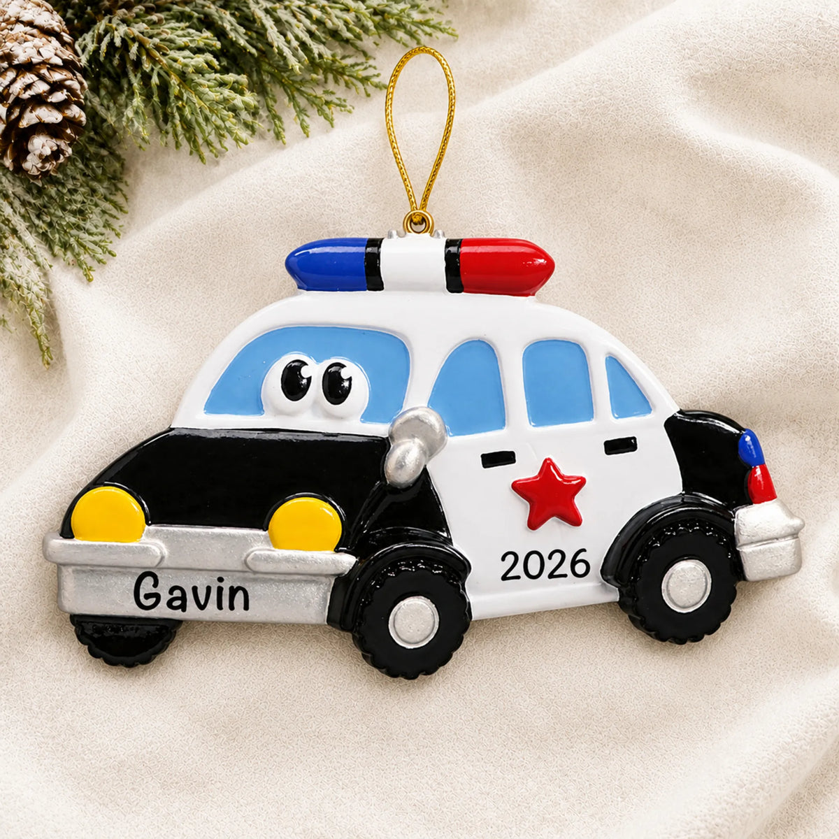 Personalized police car christmas ornament laid on a soft white knit blanket