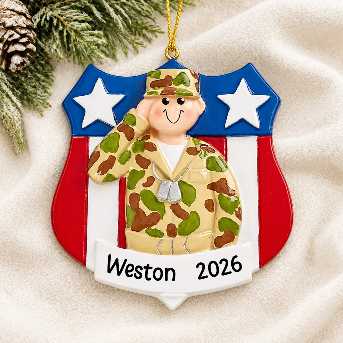 Personalized Army soldier USA shield Christmas ornament shown on a soft white blanket