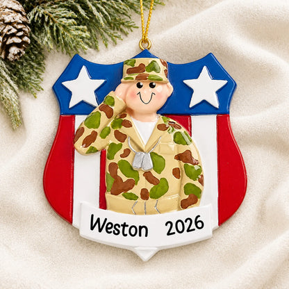 Personalized Army soldier USA shield Christmas ornament shown on a soft white blanket