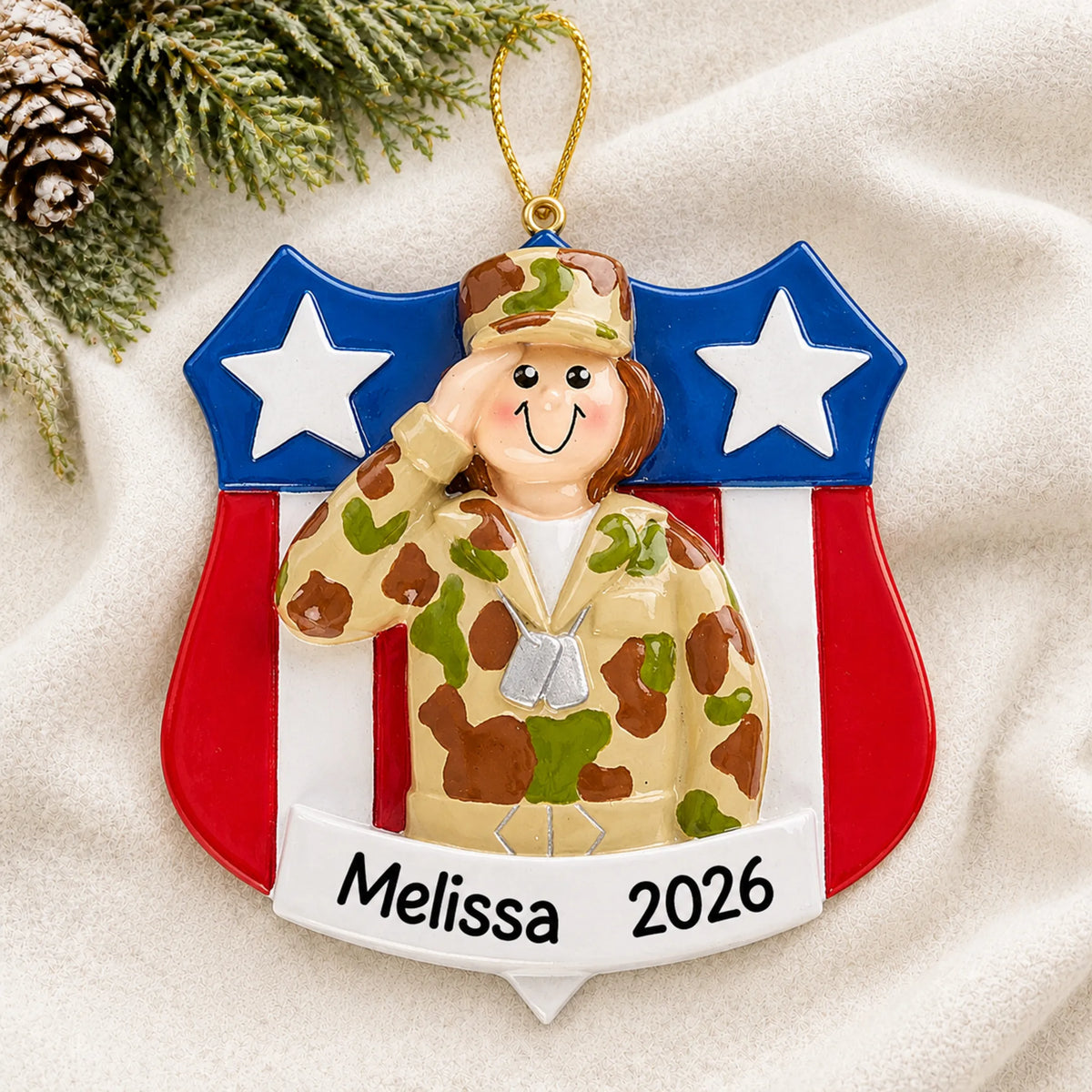 Personalized female Army soldier Christmas ornament shown on a soft white blanket