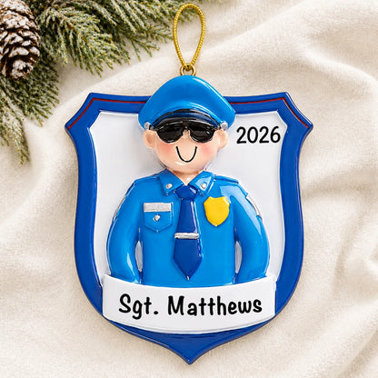 Personalized police officer guy christmas ornament laid on a soft white knit blanket