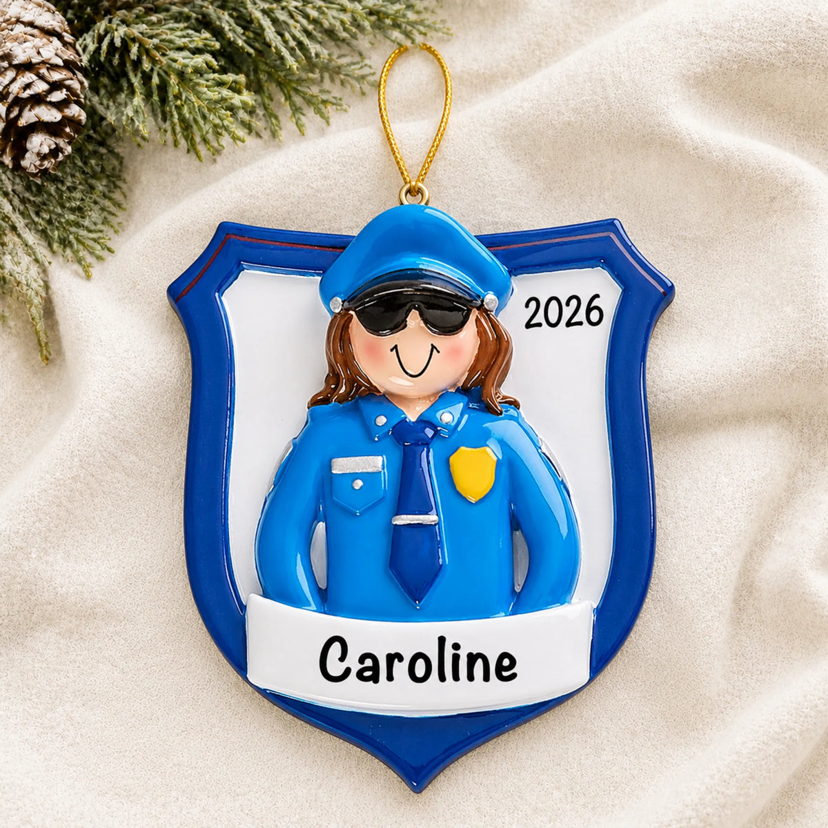 Personalized police officer woman christmas ornament laid on a soft white knit blanket