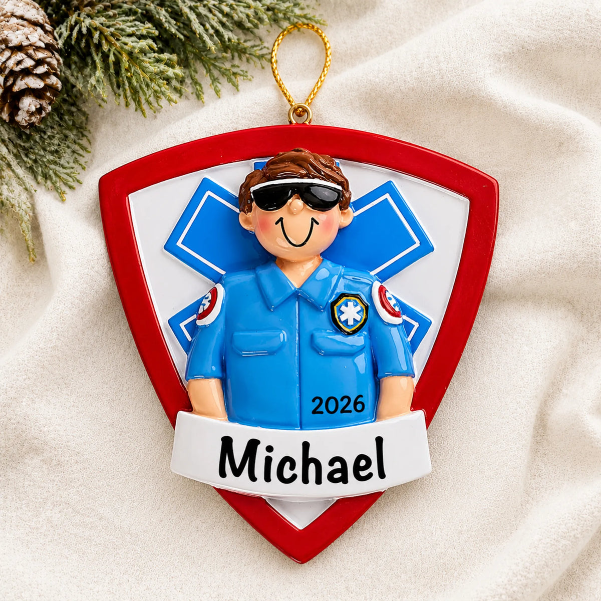 Personalized EMT paramedic christmas ornament laid on a soft white knit blanket