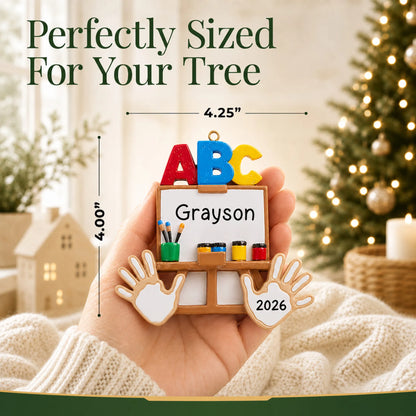 Personalized kindergarten ABC Christmas ornament held in hand to show its size on the tree