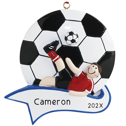 A personalized Christmas ornament featuring a soccer player in a red jersey with the text 'Cameraon and the year' on a banner, surrounded by a white and black soccer ball and a blue ribbon loop for hanging.