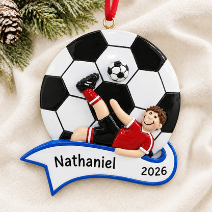 Personalized soccer kick boy christmas ornament laid on a soft white knit blanket