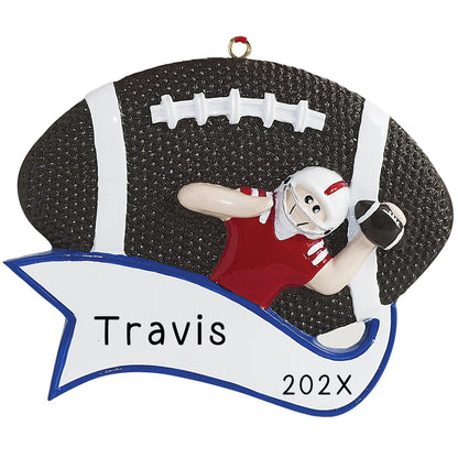 A personalized Christmas ornament featuring a football quarterback in a red jersey with a white helmet, holding a football. The name 'Travis' and the year '202x' are inscribed on the ornament.