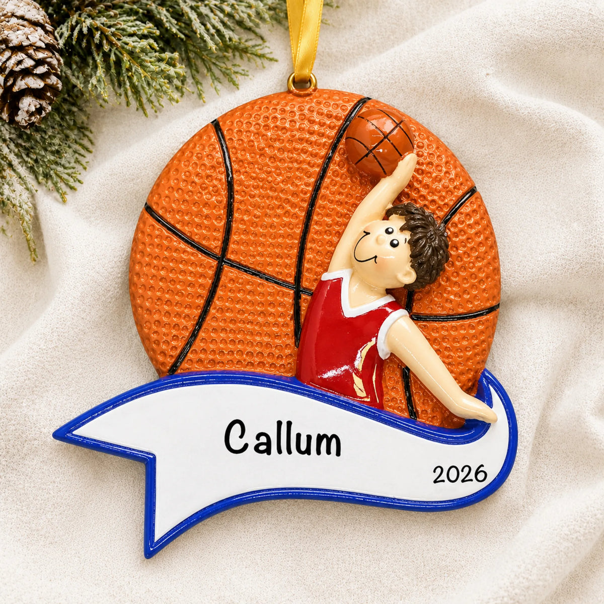 Personalized basketball dunk boy christmas ornament laid on a soft white knit blanket