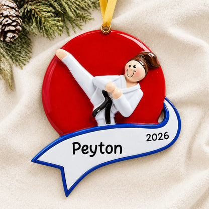 Personalized karate kick girl christmas ornament laid on a soft white knit blanket