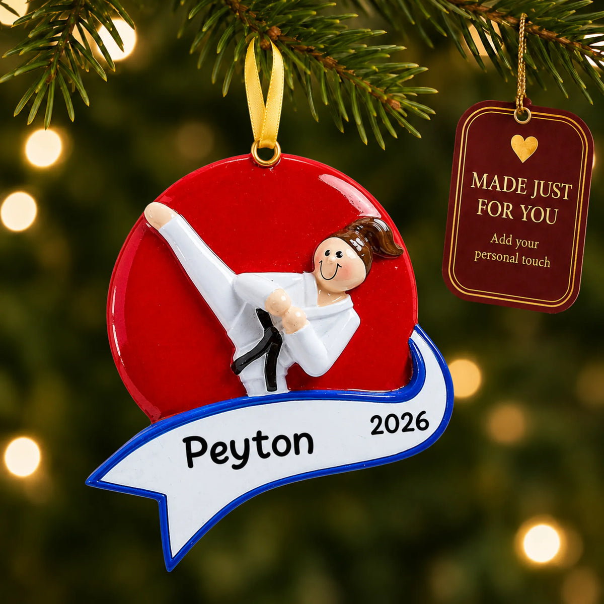 Karate kick girl christmas ornament hanging on a lit Christmas tree with a Made Just For You gift tag