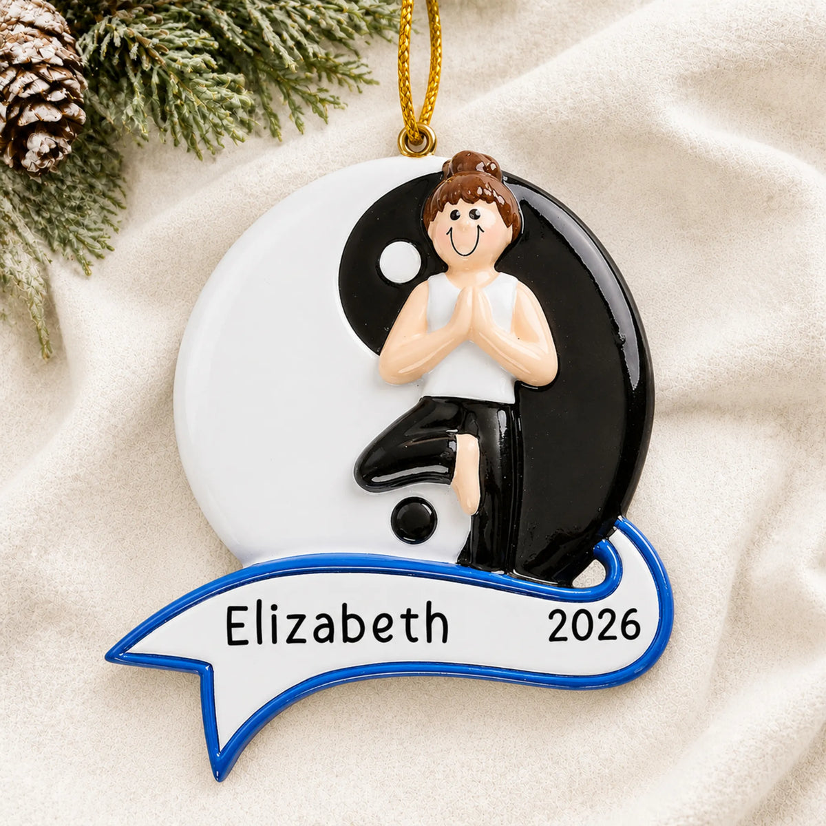 Personalized yoga yin and yang christmas ornament laid on a soft white knit blanket