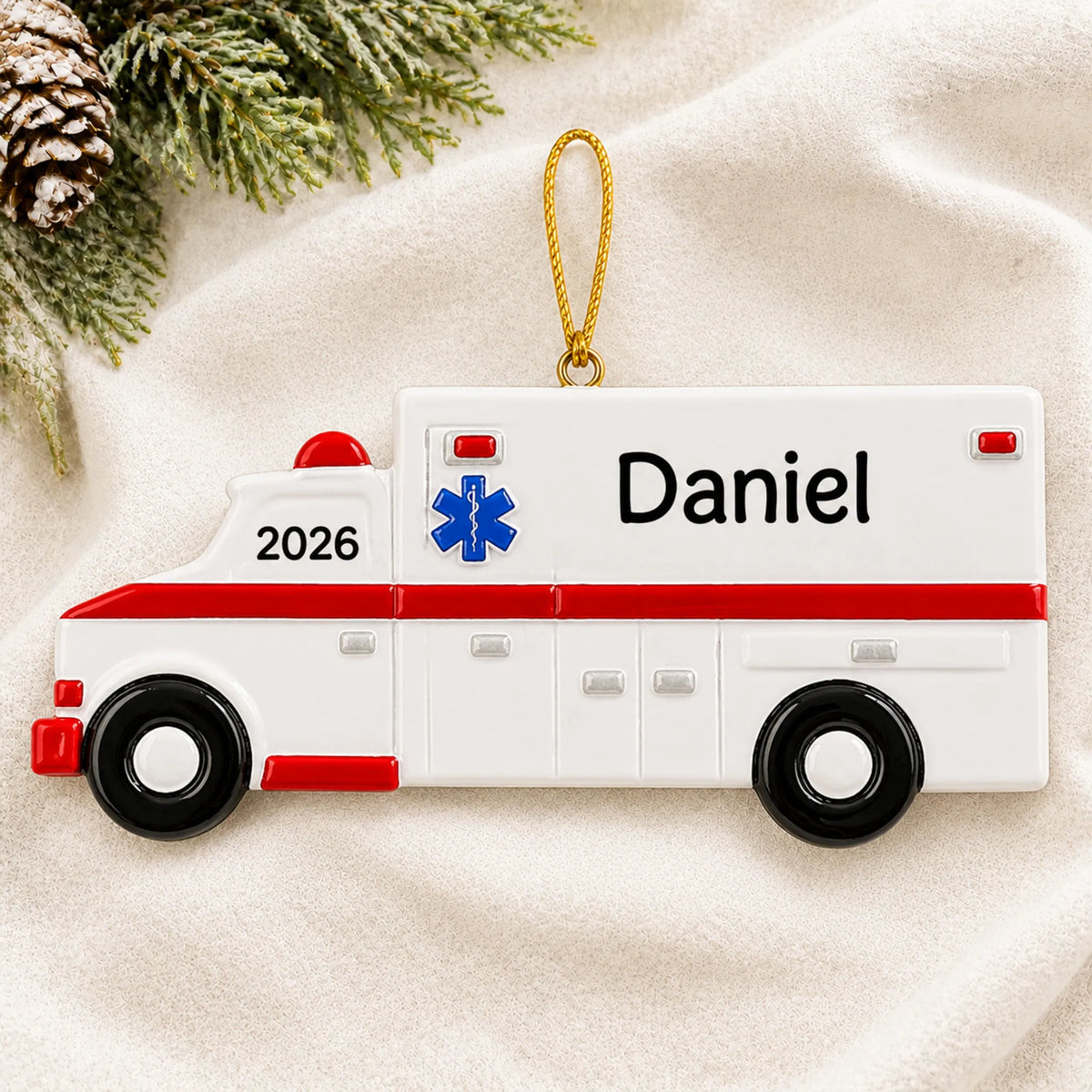 Personalized ambulance christmas ornament laid on a soft white knit blanket