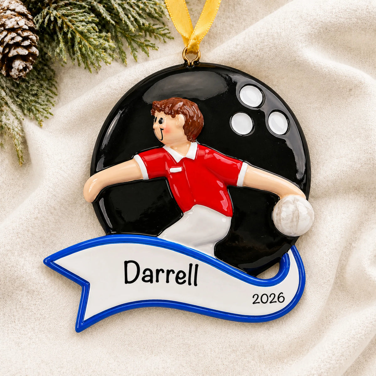 Personalized bowling guy christmas ornament laid on a soft white knit blanket