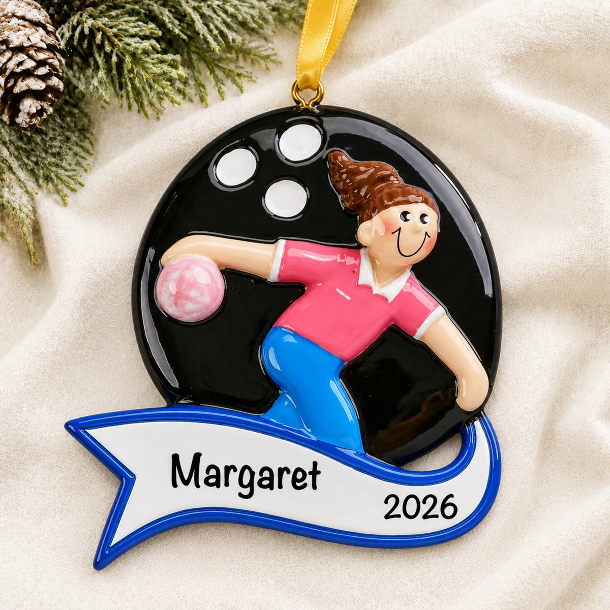 Personalized bowling girl christmas ornament laid on a soft white knit blanket