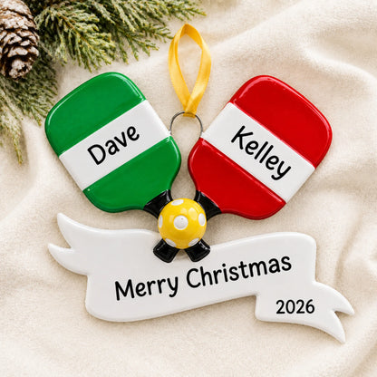 Personalized pickleball paddles christmas ornament laid on a soft white knit blanket