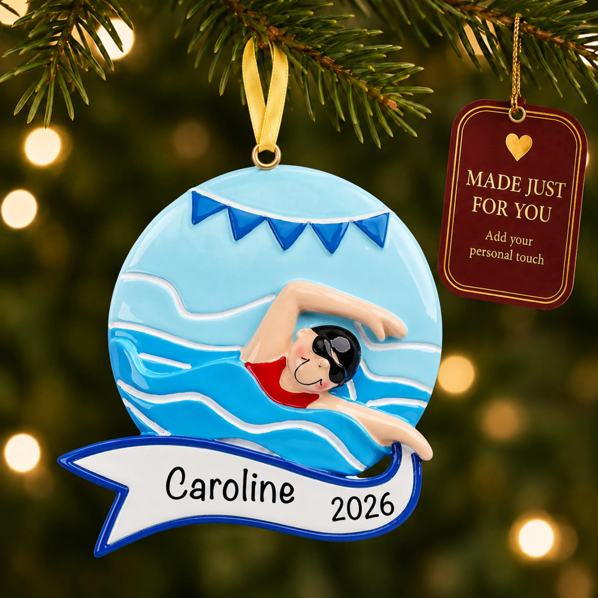 Girl swimming mid-stroke christmas ornament hanging on a lit Christmas tree with a Made Just For You gift tag