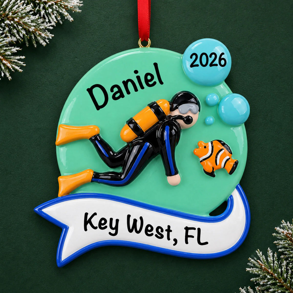 Personalized scuba diver christmas ornament, a scuba diver swimming with a clownfish, on a dark green pine background
