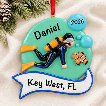 Personalized scuba diver christmas ornament laid on a soft white knit blanket