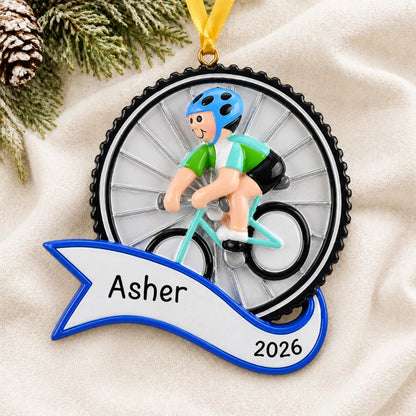 Personalized cycling boy christmas ornament laid on a soft white knit blanket
