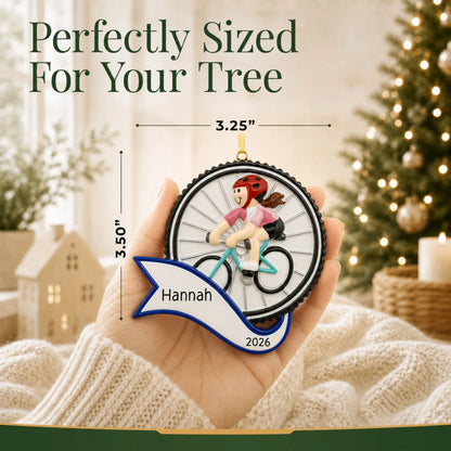 Size guide: the personalized cycling girl christmas ornament shown in hand next to a Christmas tree