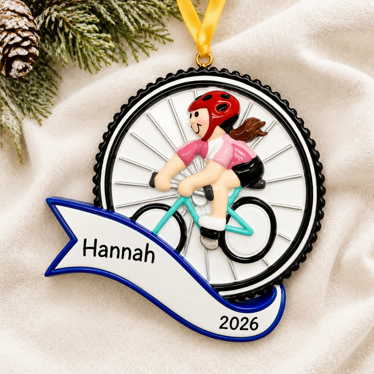 Personalized cycling girl christmas ornament laid on a soft white knit blanket