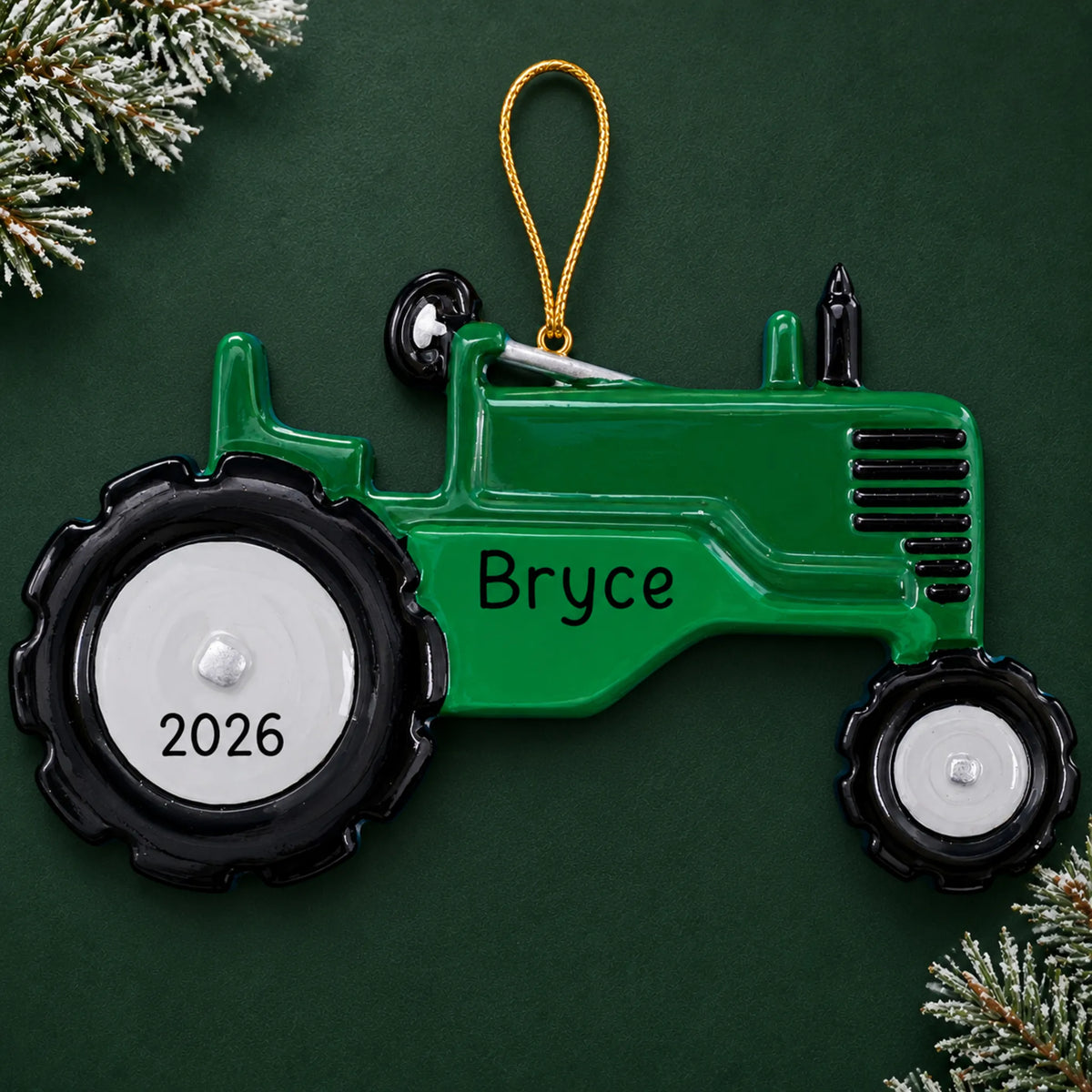Personalized green tractor christmas ornament on a dark green pine background