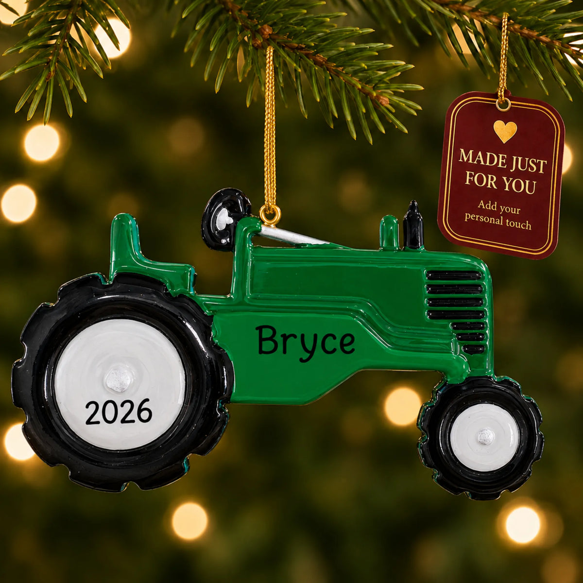 Green tractor christmas ornament hanging on a lit Christmas tree with a Made Just For You gift tag