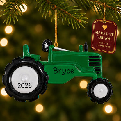 Green tractor christmas ornament hanging on a lit Christmas tree with a Made Just For You gift tag