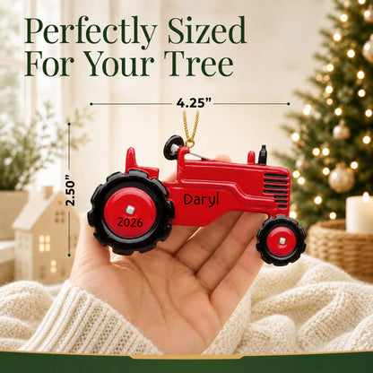 Size guide: the personalized red tractor christmas ornament is 4.25 in wide by 2.50 in tall, shown in hand