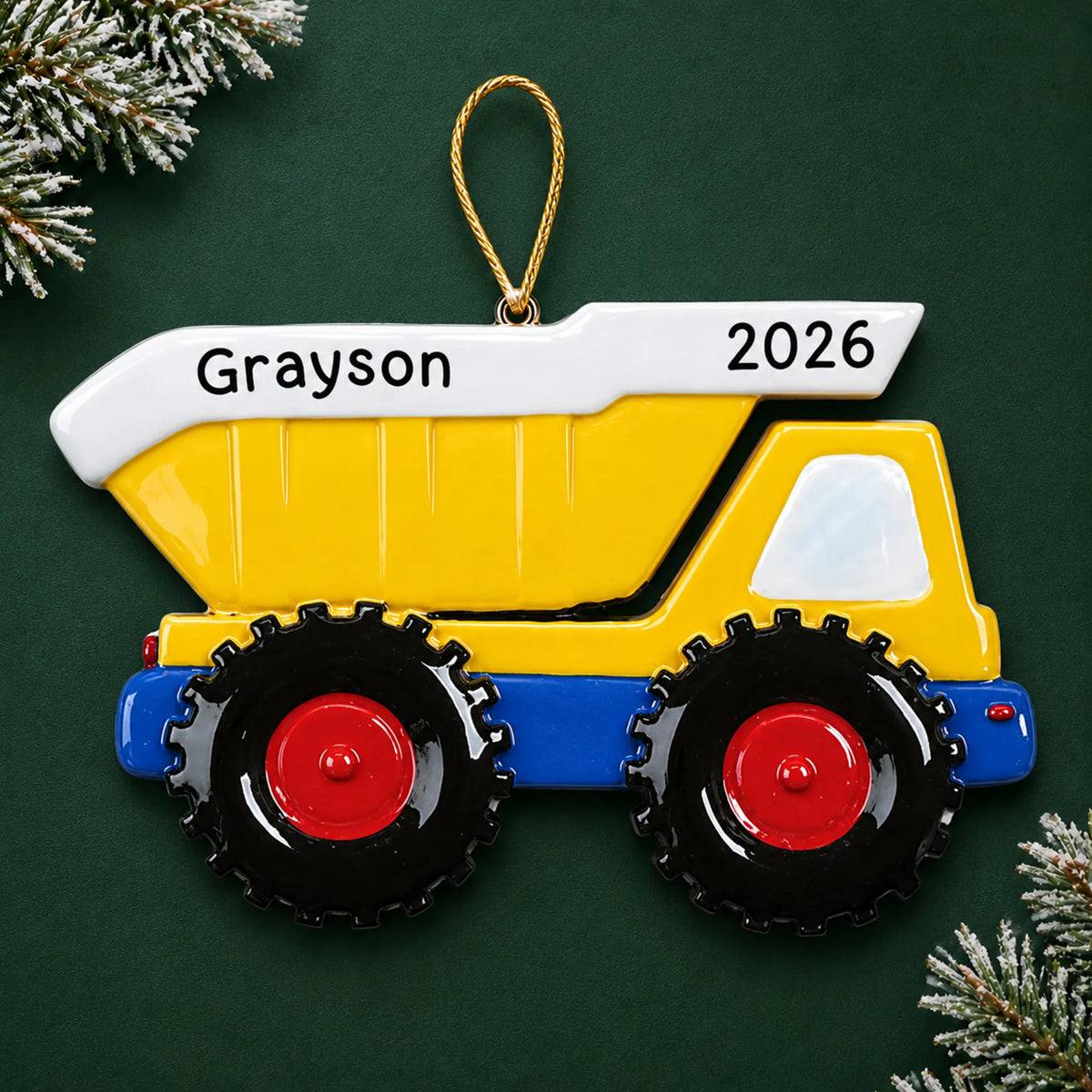 Personalized yellow kids dump truck christmas ornament on a dark green pine background