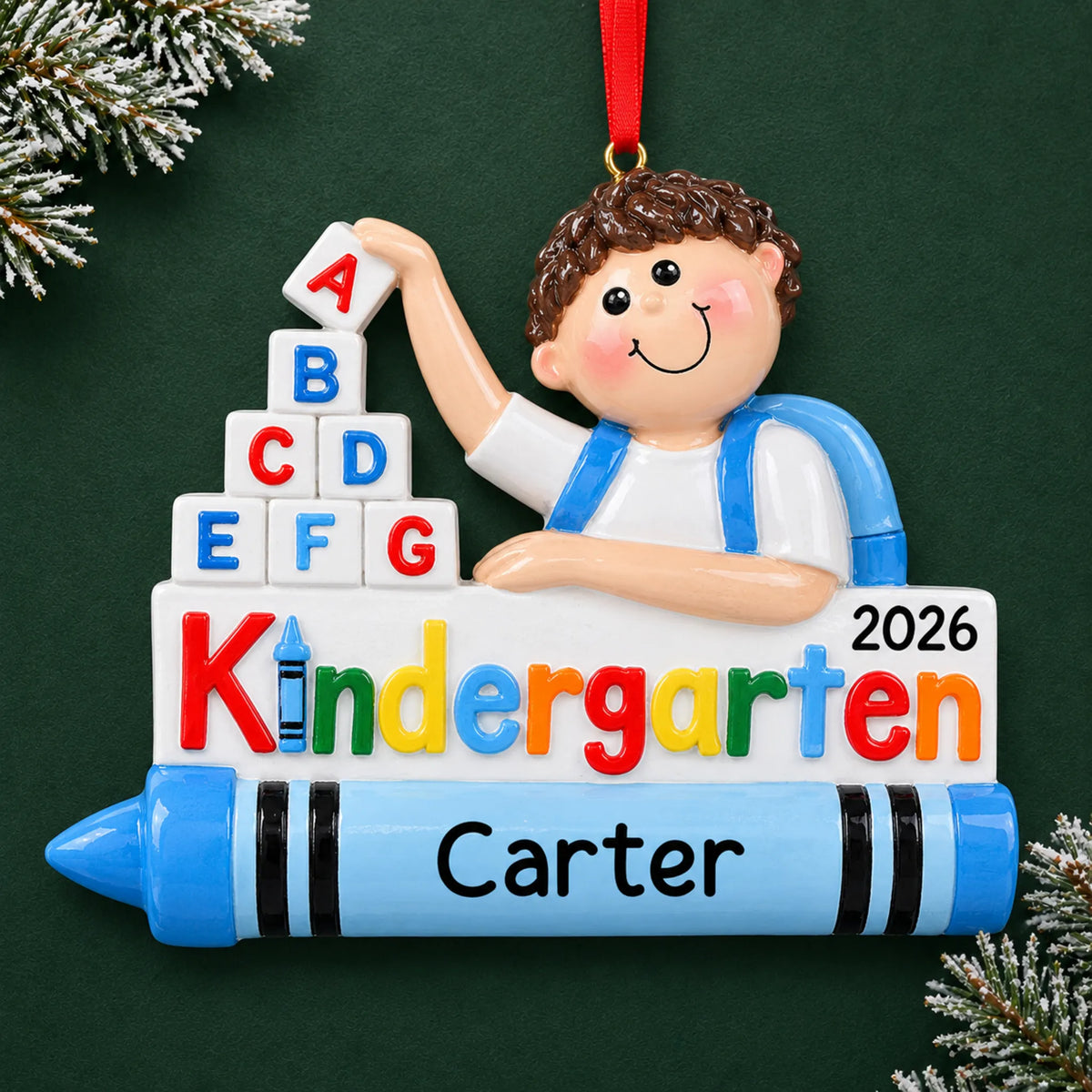 Personalized kindergarten boy Christmas ornament with name and year, shown on a green holiday background