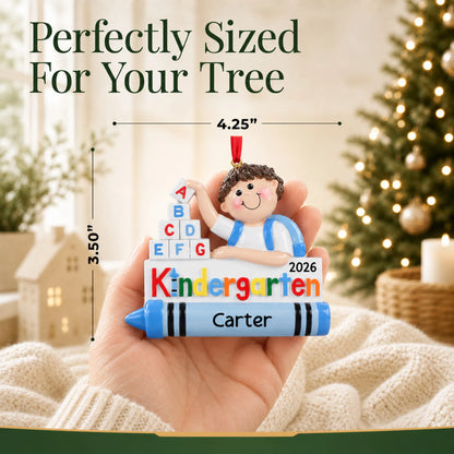 Personalized kindergarten boy Christmas ornament held in hand to show its size on the tree