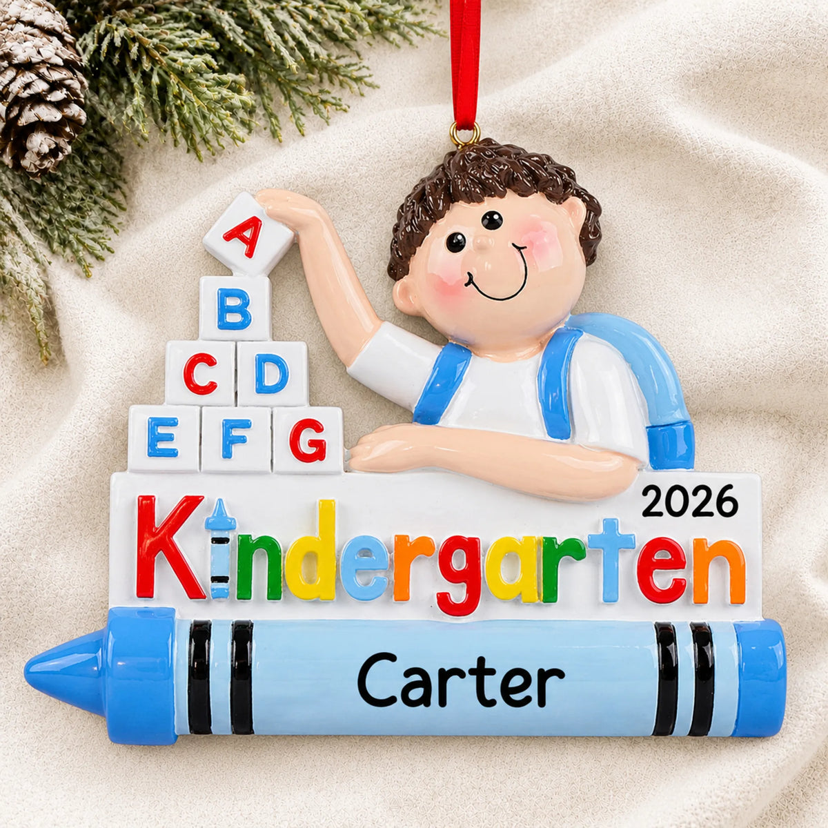 Personalized kindergarten boy Christmas ornament shown on a soft white blanket