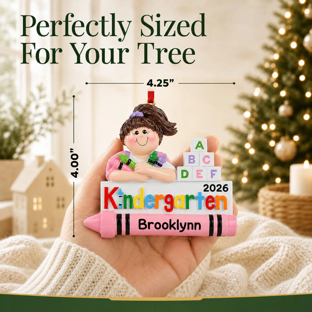 Personalized kindergarten girl Christmas ornament held in hand to show its size on the tree