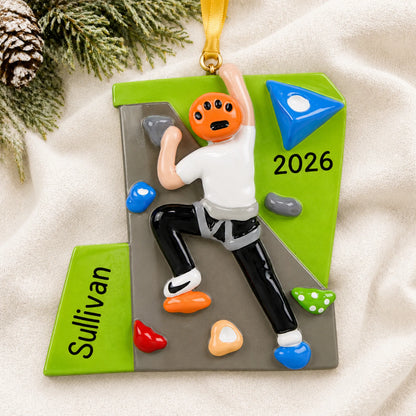 Personalized rock climber guy christmas ornament laid on a soft white knit blanket