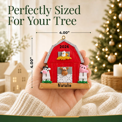 Size guide: the personalized red barn farm animals christmas ornament shown in hand next to a Christmas tree