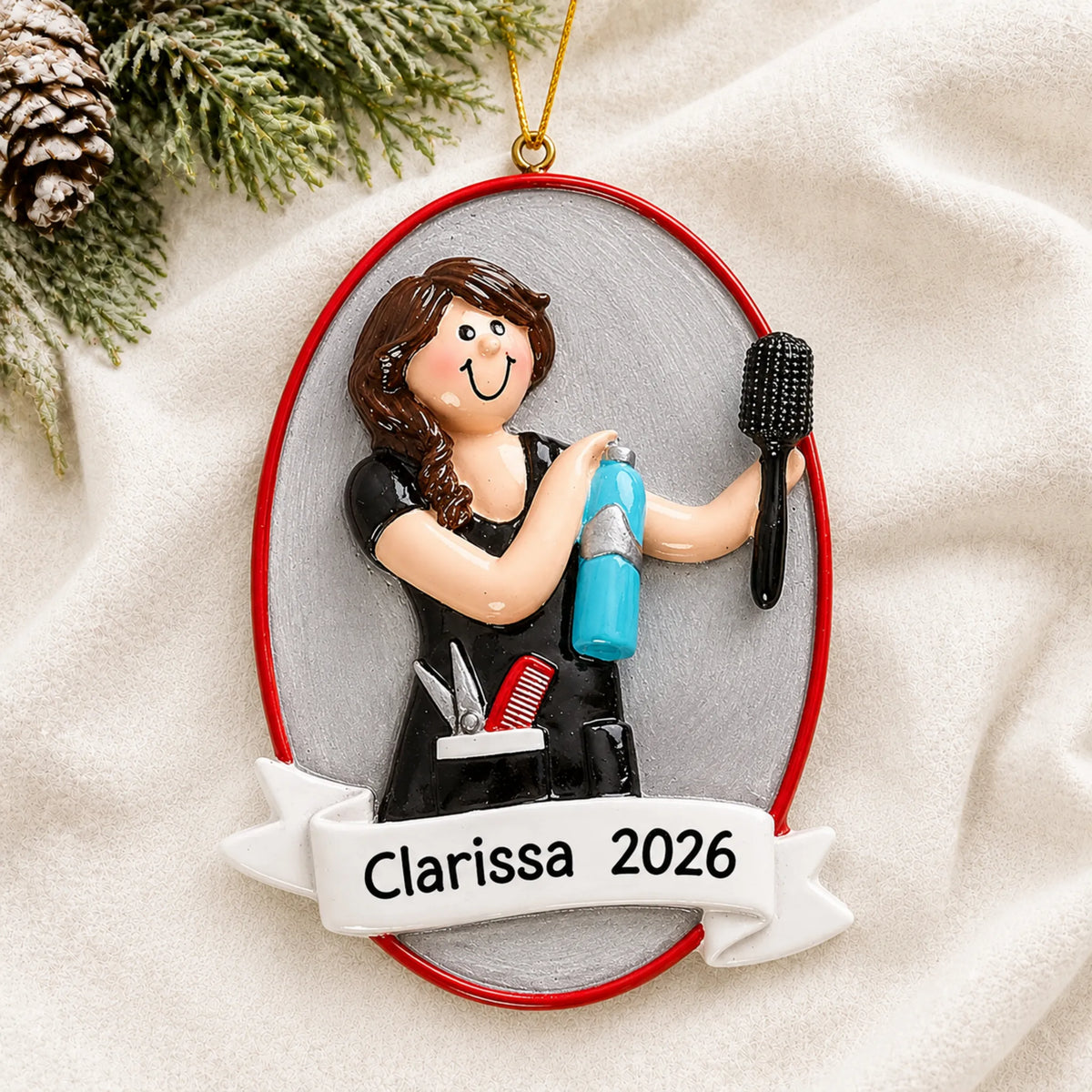 Personalized cosmetologist christmas ornament laid on a soft white knit blanket