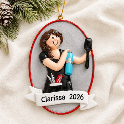 Personalized cosmetologist christmas ornament laid on a soft white knit blanket