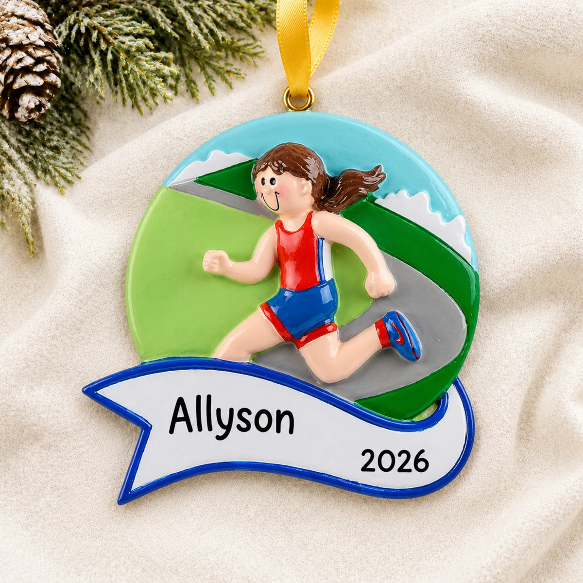 Personalized jogger girl christmas ornament laid on a soft white knit blanket