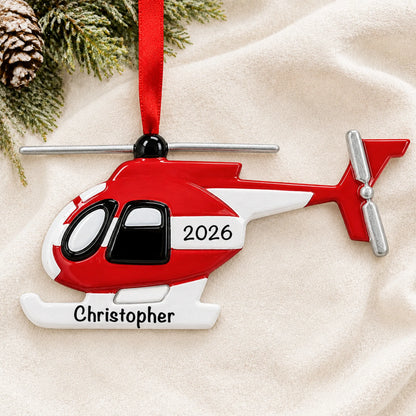 Personalized helicopter christmas ornament laid on a soft white knit blanket
