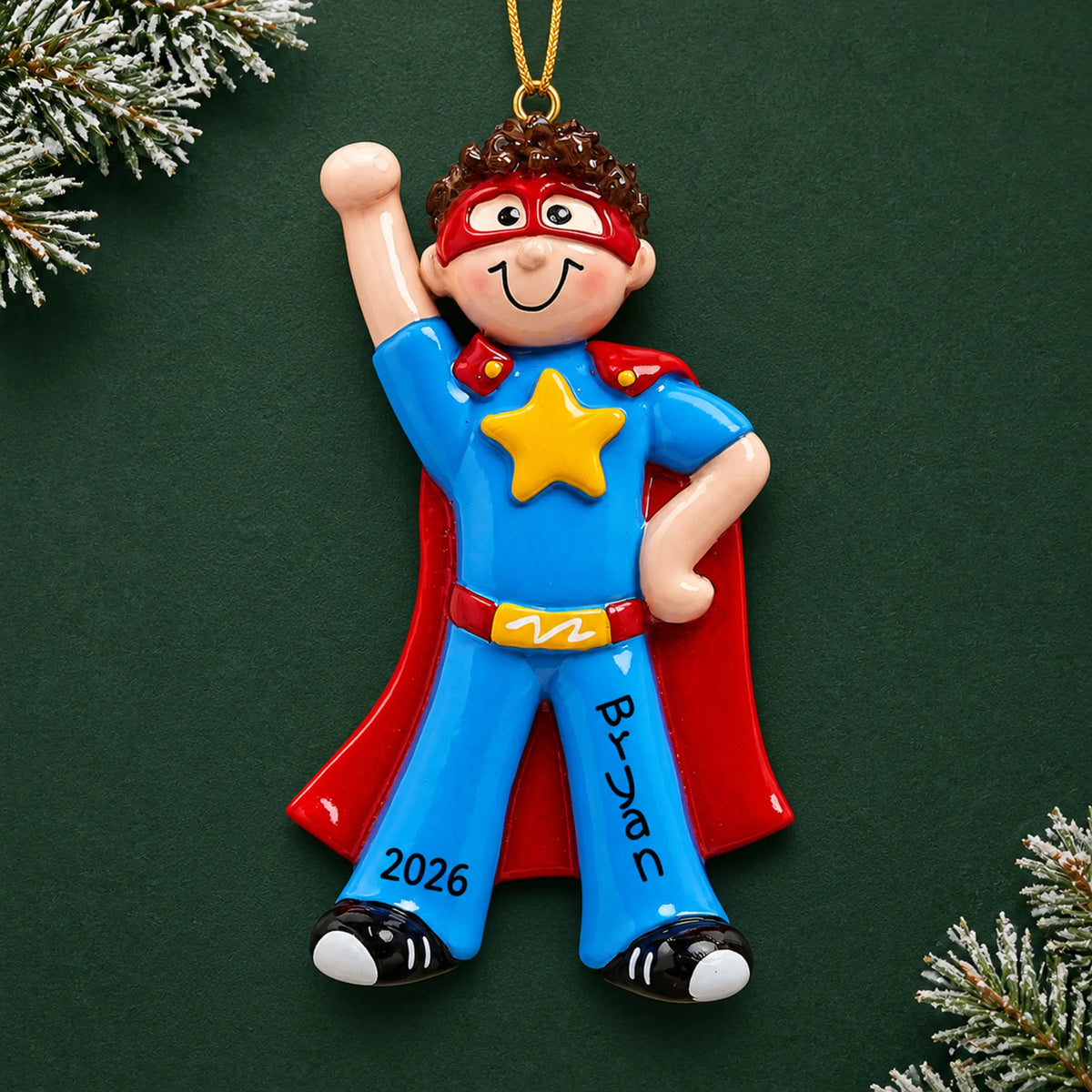 Personalized super hero boy christmas ornament on a dark green pine background
