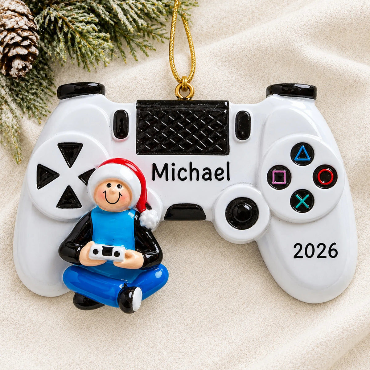 Personalized video game controller christmas ornament laid on a soft white knit blanket