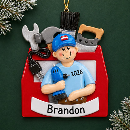 Personalized handyman toolbox christmas ornament on a dark green pine background