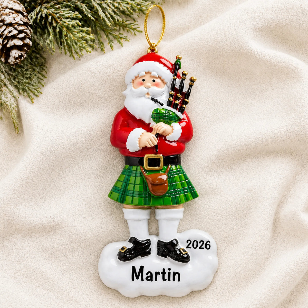 Personalized Scottish Bagpipes Santa christmas ornament laid on a soft white knit blanket