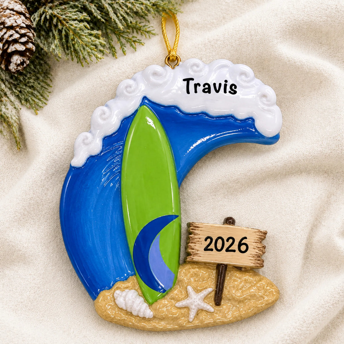 Personalized surfing big wave christmas ornament laid on a soft white knit blanket