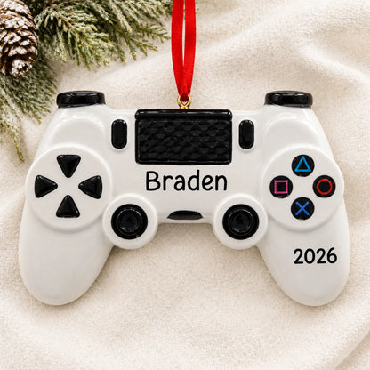 Personalized gaming controller christmas ornament laid on a soft white knit blanket