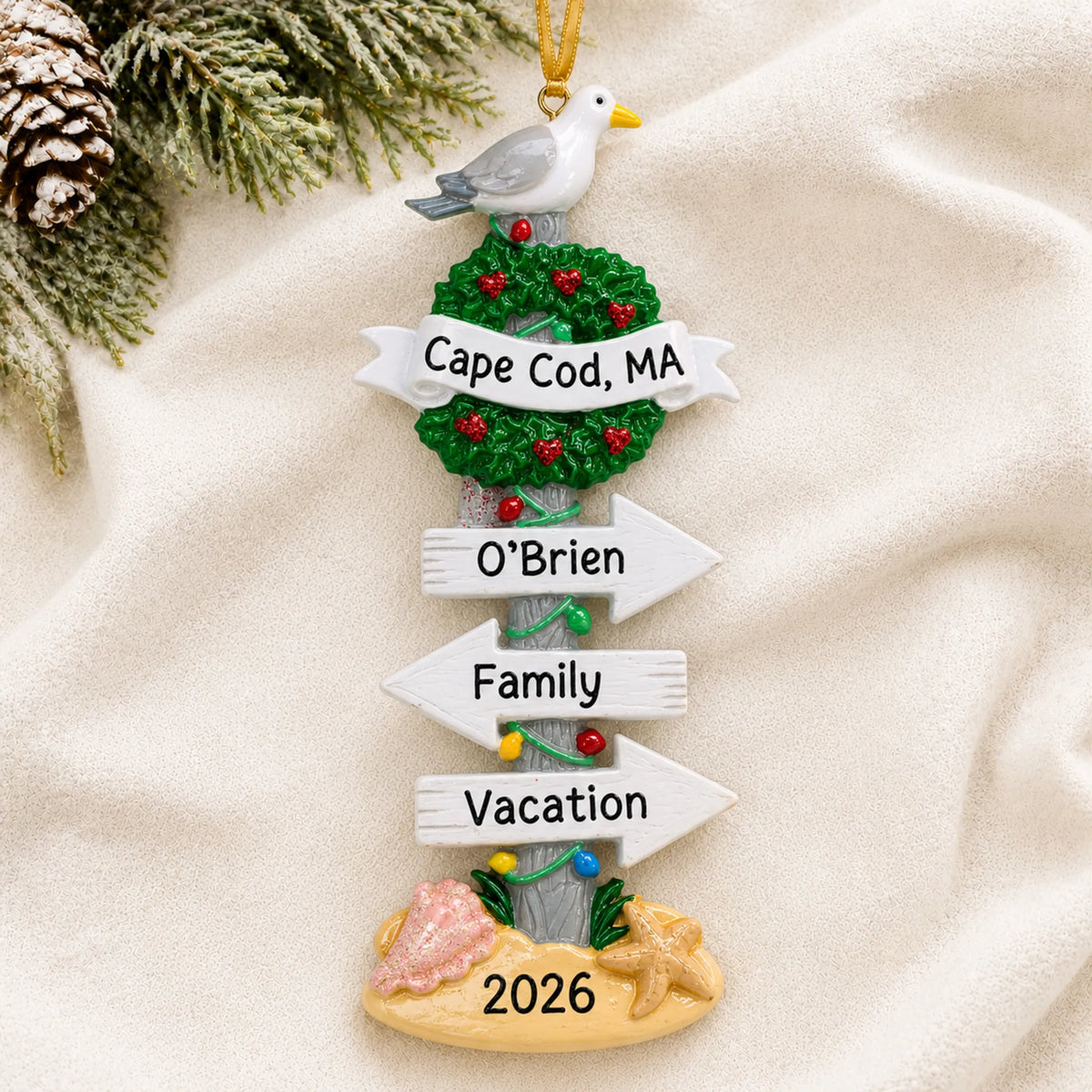 Personalized beach signs christmas ornament laid on a soft white knit blanket